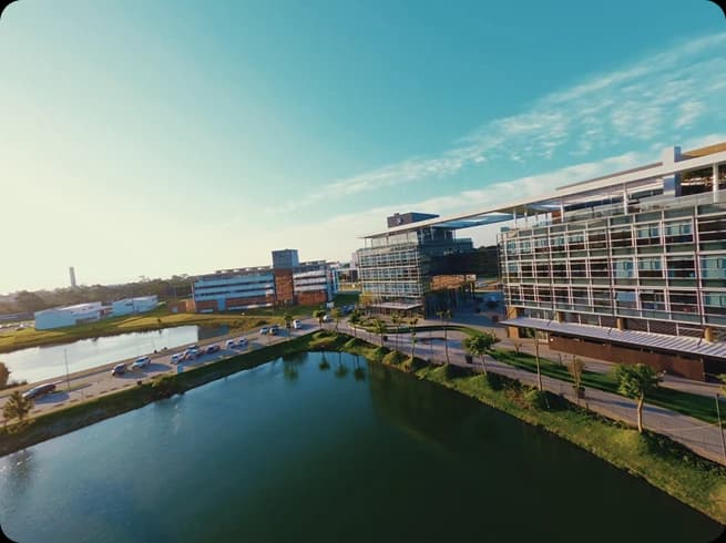 Vista aérea diurna do Sapiens Parque com lago ao fundo